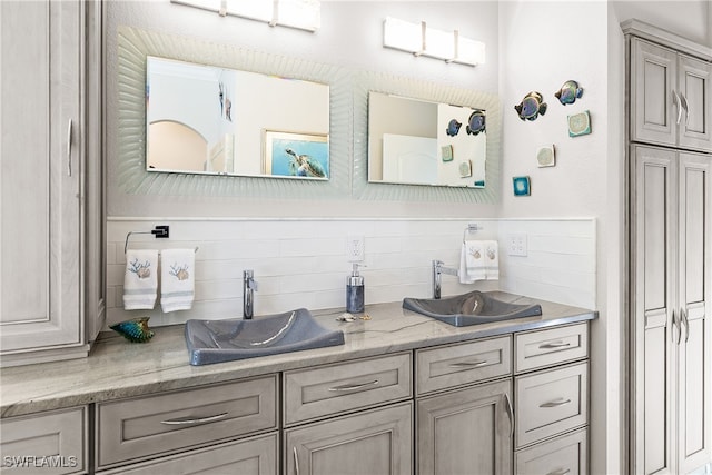 bar with light stone countertops, tasteful backsplash, and sink