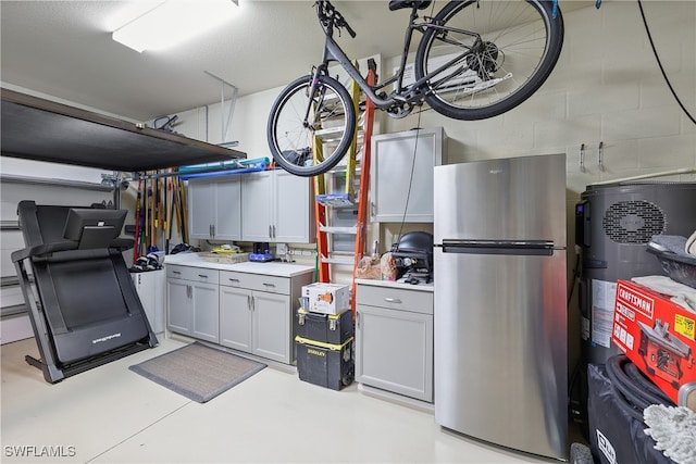 basement with stainless steel fridge and a textured ceiling