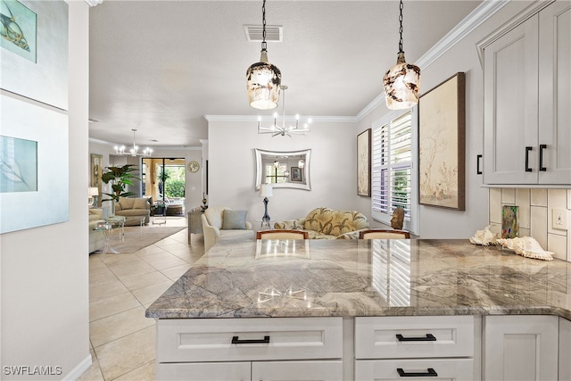 kitchen with crown molding, white cabinets, and an inviting chandelier