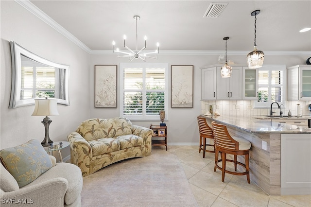 living room featuring a wealth of natural light, crown molding, light tile patterned floors, and sink