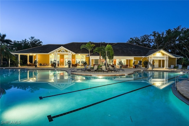 pool at dusk with a patio area