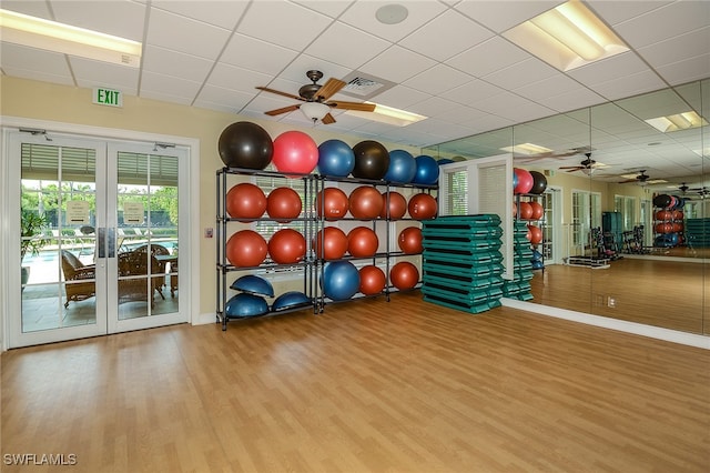 workout area with light wood-type flooring and a drop ceiling