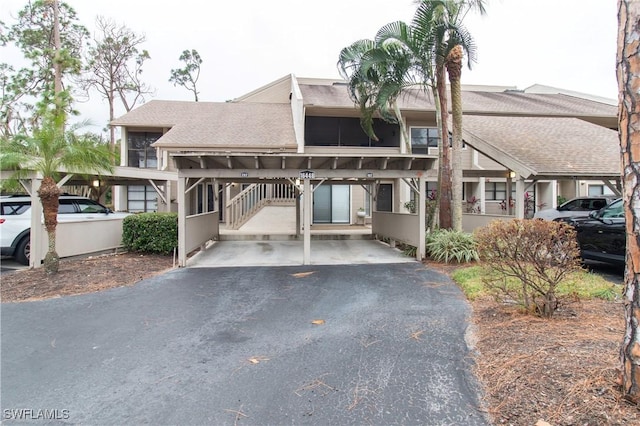 16448 Timberlakes Dr Unit 202, Fort Myers, FL 33908 - view of property featuring a shingled roof and a carport