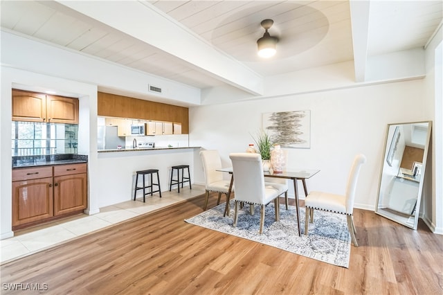 dining space featuring light hardwood / wood-style floors, beamed ceiling, ceiling fan, and wooden ceiling