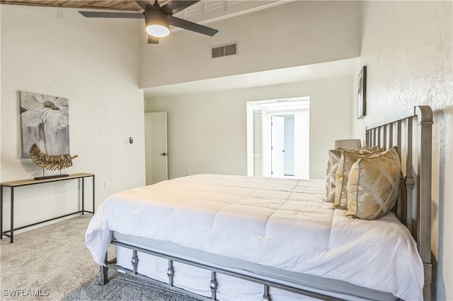 carpeted bedroom featuring ceiling fan and a towering ceiling