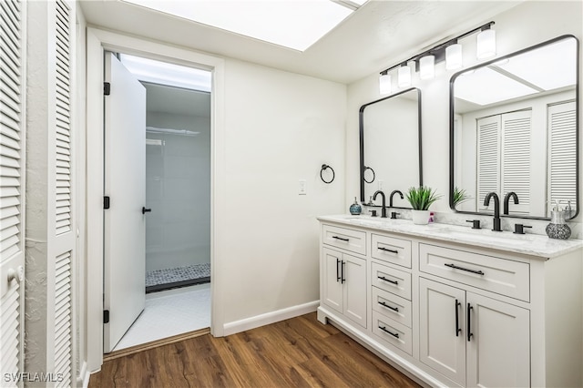 bathroom featuring hardwood / wood-style flooring, vanity, and walk in shower