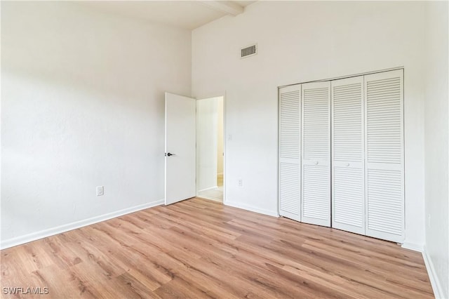 16448 Timberlakes Dr Unit 202, Fort Myers, FL 33908 - unfurnished bedroom with high vaulted ceiling, light wood-type flooring, beamed ceiling, baseboards, and a closet