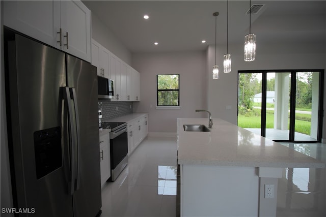 kitchen featuring a wealth of natural light, white cabinetry, appliances with stainless steel finishes, and sink