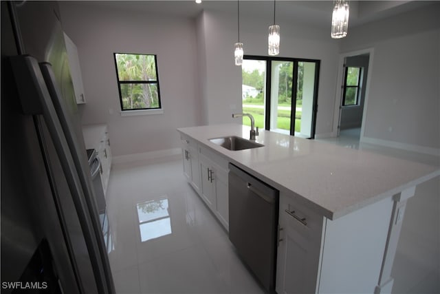 kitchen with white cabinets, stainless steel appliances, a kitchen island with sink, and sink