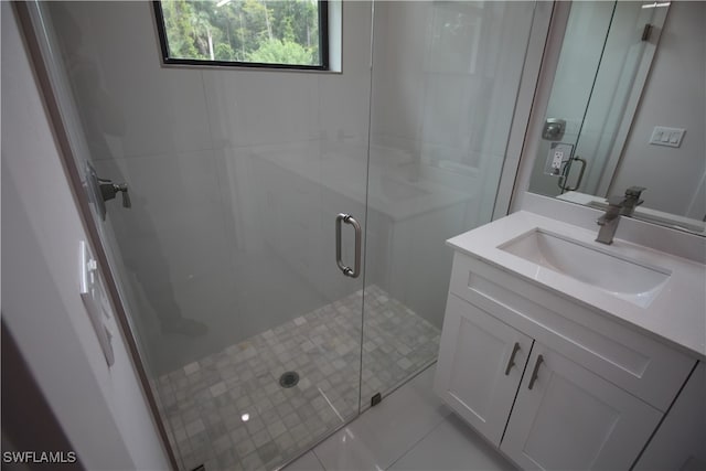 bathroom with an enclosed shower, vanity, and tile patterned floors