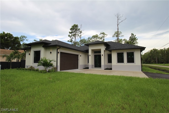 prairie-style house featuring a front lawn and a garage