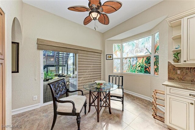 tiled dining space featuring plenty of natural light and ceiling fan