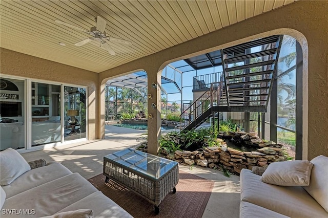 view of patio / terrace featuring outdoor lounge area, ceiling fan, and glass enclosure