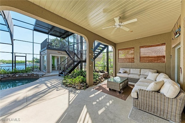 sunroom with a water view, ceiling fan, and a swimming pool