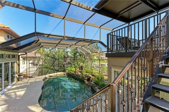 view of swimming pool with glass enclosure and a patio