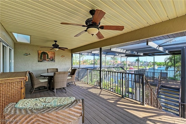 wooden deck with ceiling fan and a water view