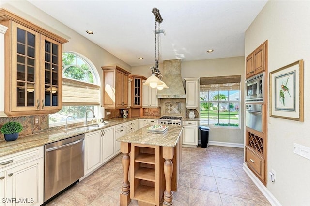 kitchen with premium range hood, tasteful backsplash, a kitchen island, and appliances with stainless steel finishes