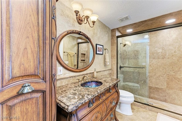 bathroom with vanity, tile patterned floors, toilet, a textured ceiling, and walk in shower