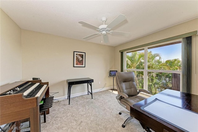 office space featuring a textured ceiling, light colored carpet, and ceiling fan