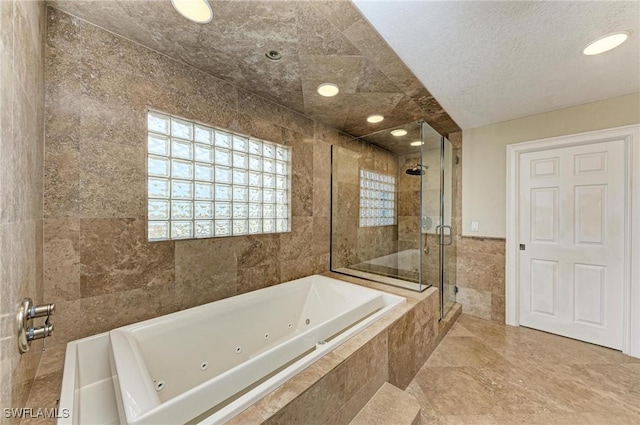 bathroom featuring a textured ceiling, tile walls, and plus walk in shower