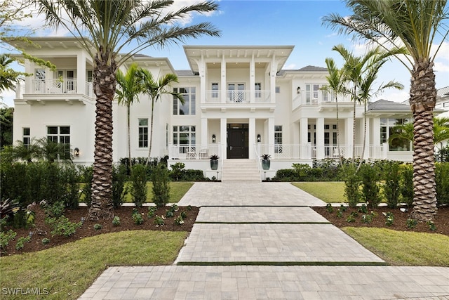 view of front of home with a balcony and a front yard