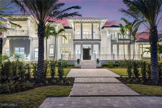 view of front of house featuring a yard and a balcony