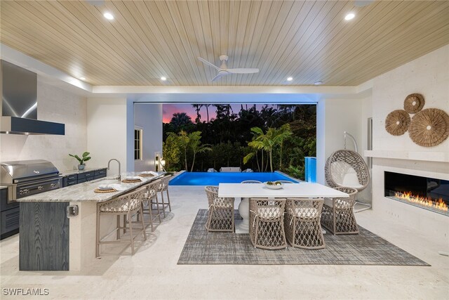 view of patio featuring a grill, an outdoor bar, and exterior kitchen