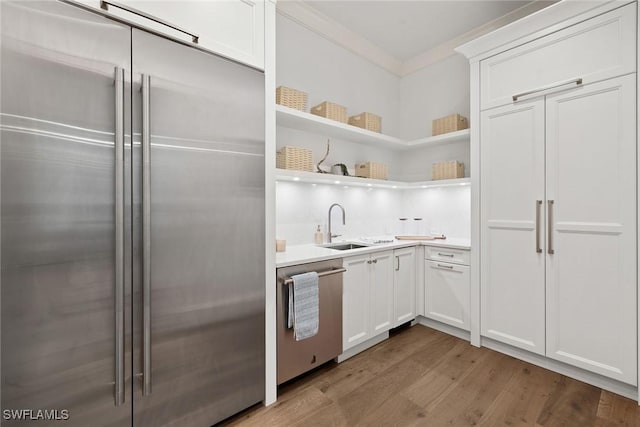 12 Sabre Ln, Naples, FL 34102 - kitchen featuring stainless steel appliances, wood finished floors, white cabinetry, light countertops, and open shelves