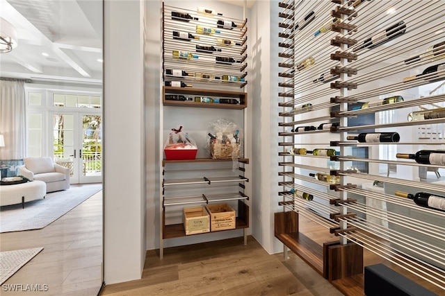 wine cellar with wood-type flooring, coffered ceiling, and beam ceiling