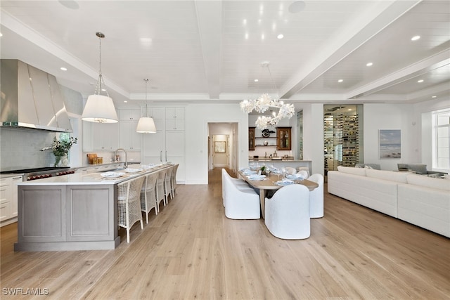 dining area with beamed ceiling and light wood-type flooring