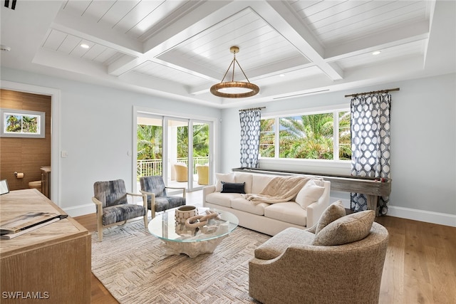 living room featuring beamed ceiling, light wood-type flooring, and plenty of natural light