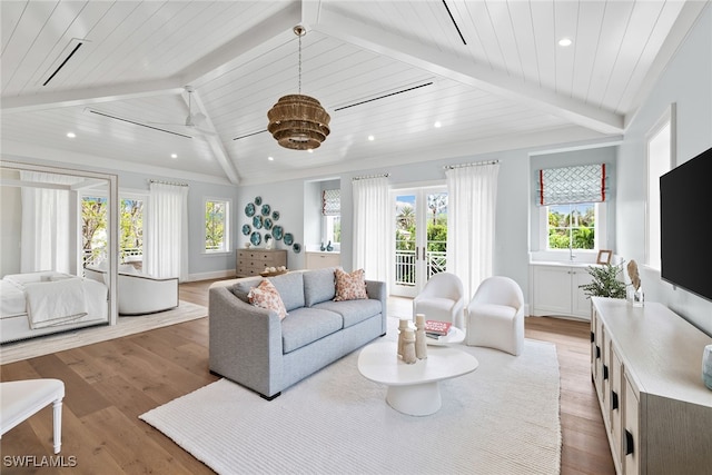 living room with vaulted ceiling with beams, a healthy amount of sunlight, light wood-type flooring, and wood ceiling