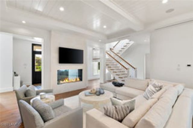 living room featuring beam ceiling and hardwood / wood-style floors