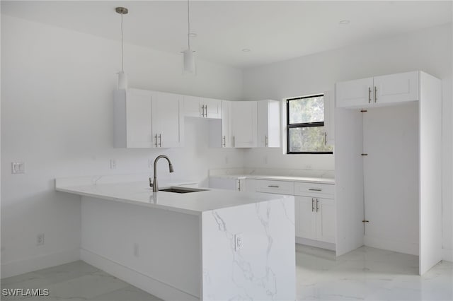 735 Goldrock Rd, Lehigh Acres, FL 33974 - kitchen with light marble finish floors, a sink, baseboards, and white cabinetry