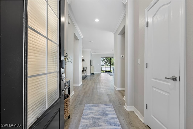 hallway with light hardwood / wood-style flooring and crown molding