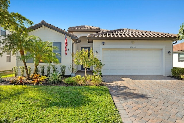 mediterranean / spanish house with a garage and a front yard