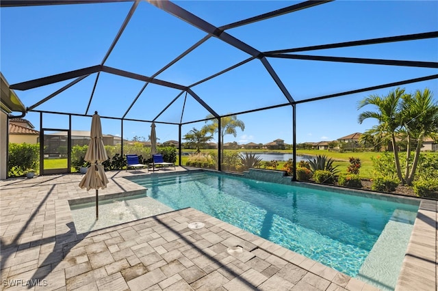 view of pool featuring a patio area, glass enclosure, and a water view