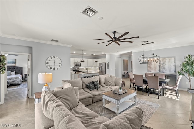 tiled living room with ceiling fan with notable chandelier, sink, and crown molding