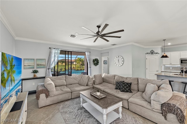 living room with ceiling fan, sink, light tile patterned floors, and ornamental molding