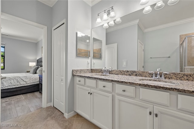 bathroom with vanity, tile patterned flooring, crown molding, and a shower with door