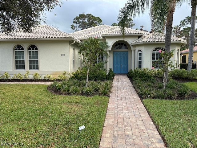 mediterranean / spanish house featuring a front yard