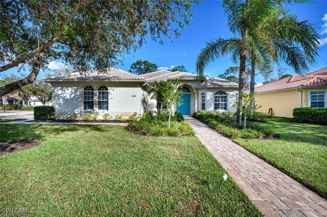 mediterranean / spanish-style house featuring a front lawn and a garage