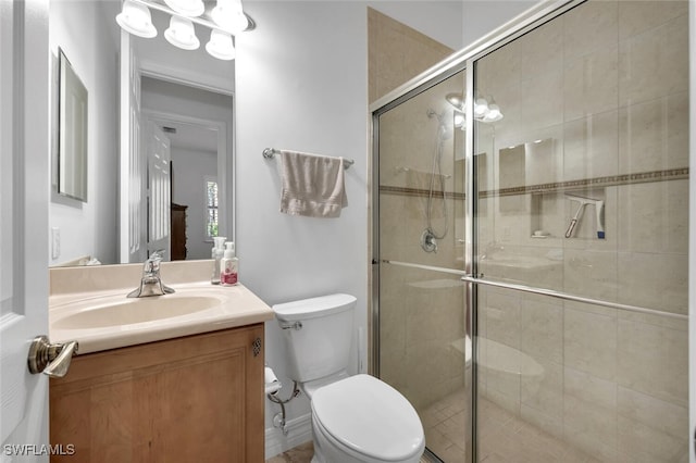 bathroom with vanity, toilet, and an enclosed shower