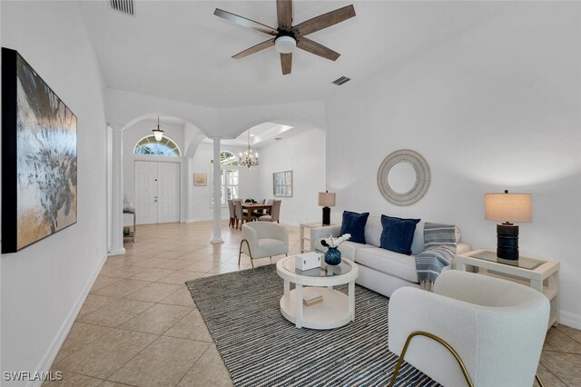 tiled living room featuring ceiling fan and ornate columns