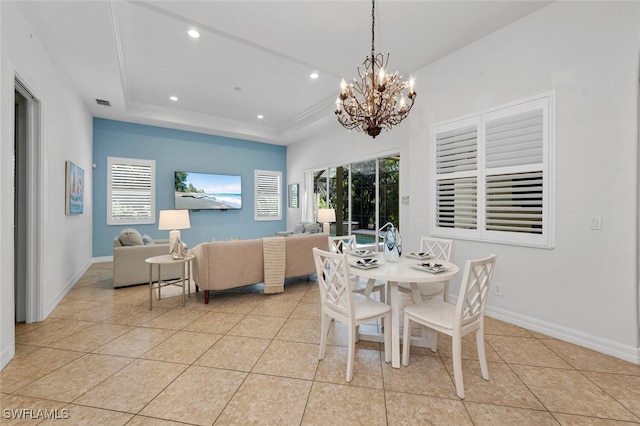 dining area featuring light tile patterned floors and a tray ceiling