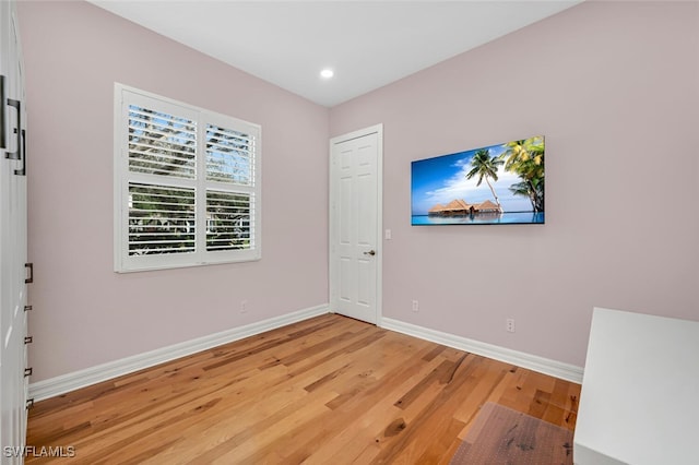 empty room featuring recessed lighting, light wood-style floors, and baseboards
