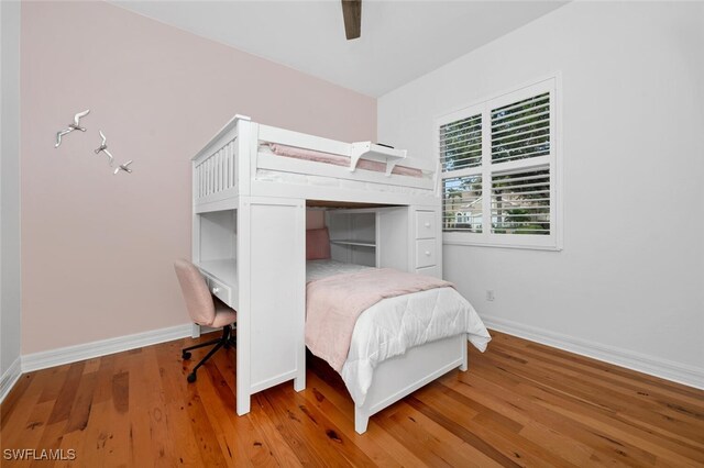 bedroom with baseboards, a ceiling fan, and light wood-type flooring