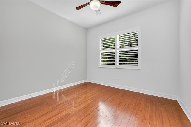 empty room featuring wood-type flooring, baseboards, and ceiling fan