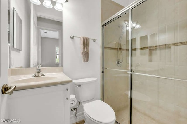 full bathroom with toilet, vanity, and a stall shower