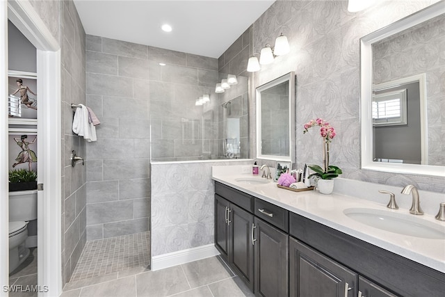 bathroom featuring tiled shower, tile patterned floors, toilet, and vanity